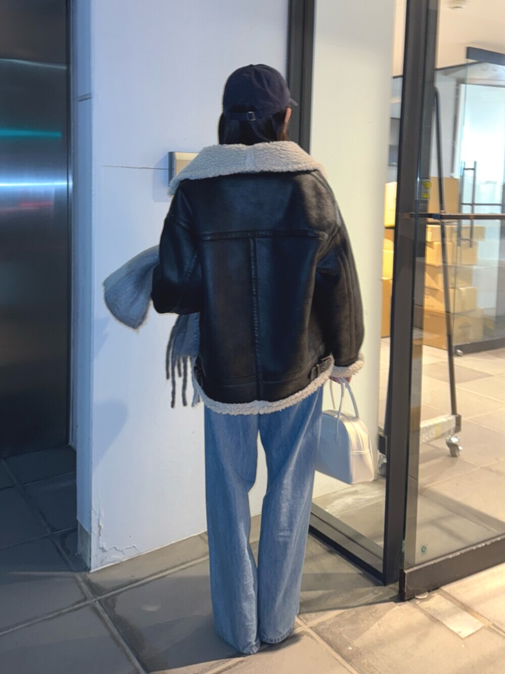 ブラウン系のブーツ、ブルー系のデニムパンツ、イエロー系のニット/セーターを着用したレディースの冬コーディネートの4枚目の写真