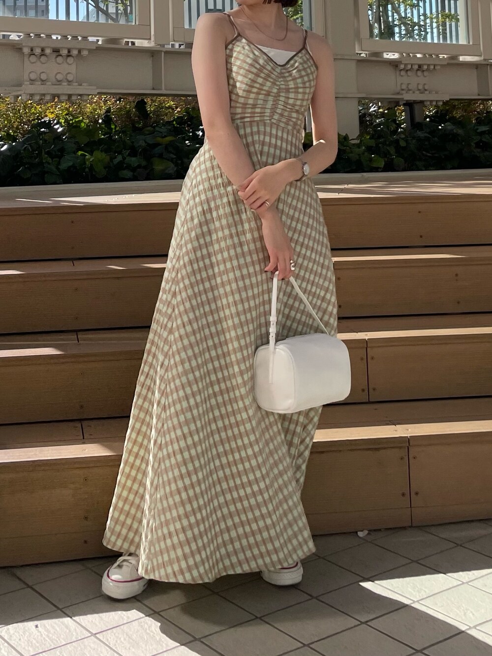 ホワイト系のハンドバッグ、グリーン系のワンピース、ブルー系のデニムジャケットを着用したレディースの冬コーディネートの3枚目の写真