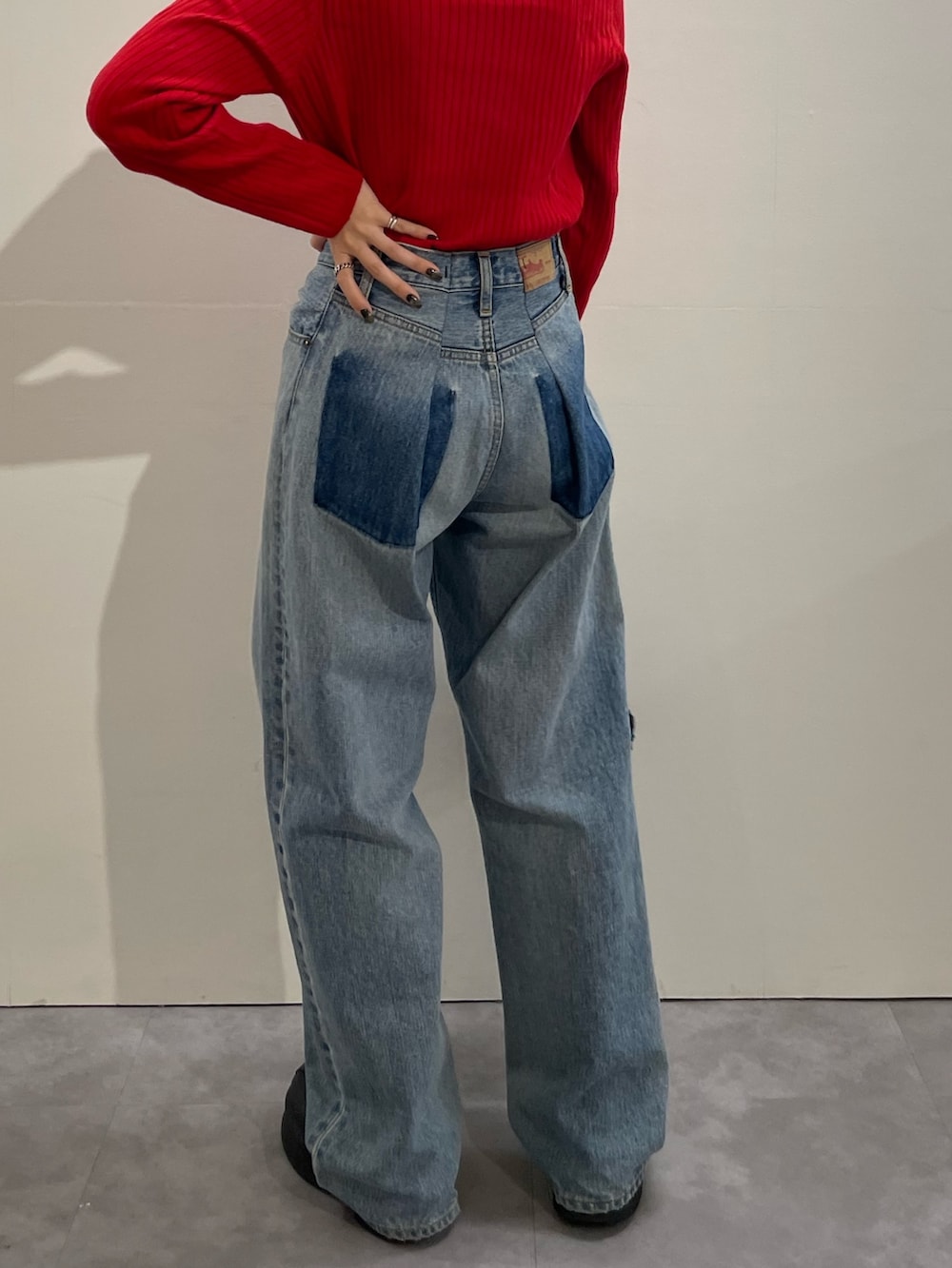 ブルー系のデニムパンツ、ブラック系のハンドバッグ、ブラック系のブーツを着用したレディースの冬コーディネートの4枚目の写真