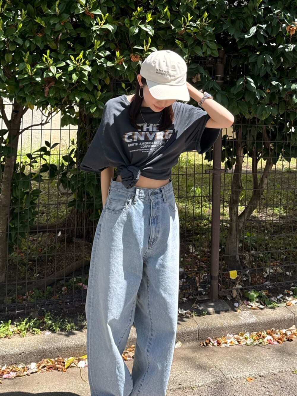 ブルー系のデニムパンツ、ブラック系のサンダル、グレー系のTシャツ/カットソーを着用したレディースの春コーディネートの6枚目の写真