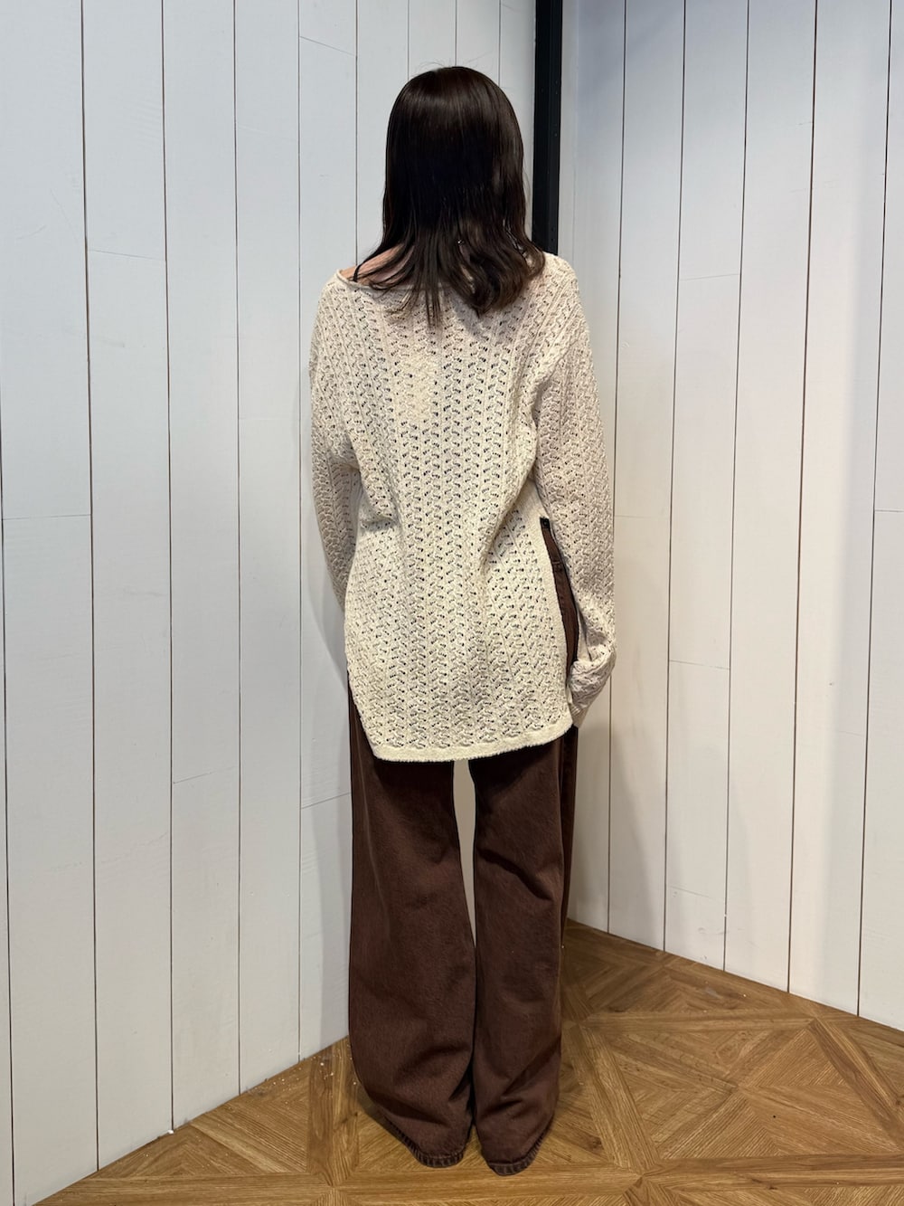 ブラウン系のデニムパンツ、ブラック系のサンダル、ベージュ系のニット/セーターを着用したレディースの春コーディネートの4枚目の写真