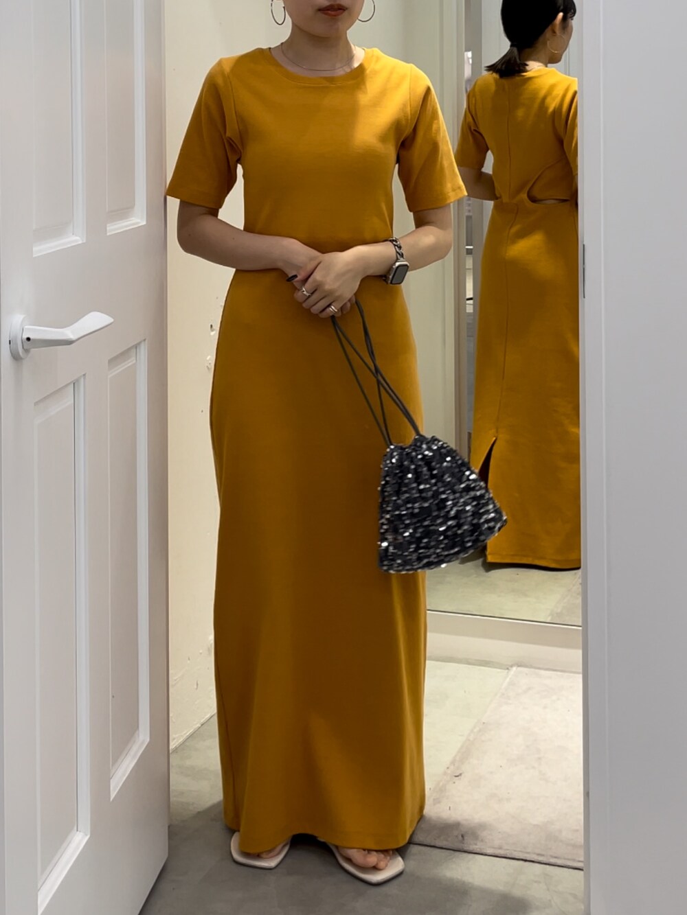 ホワイト系のサンダル、オレンジ系のワンピースを着用したレディースの夏コーディネートの2枚目の写真