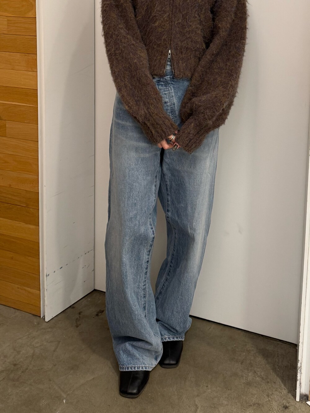 ブルー系のデニムパンツ、ブラック系のブーツ、ブラウン系のカーディガン/ボレロを着用したレディースの冬コーディネートの6枚目の写真