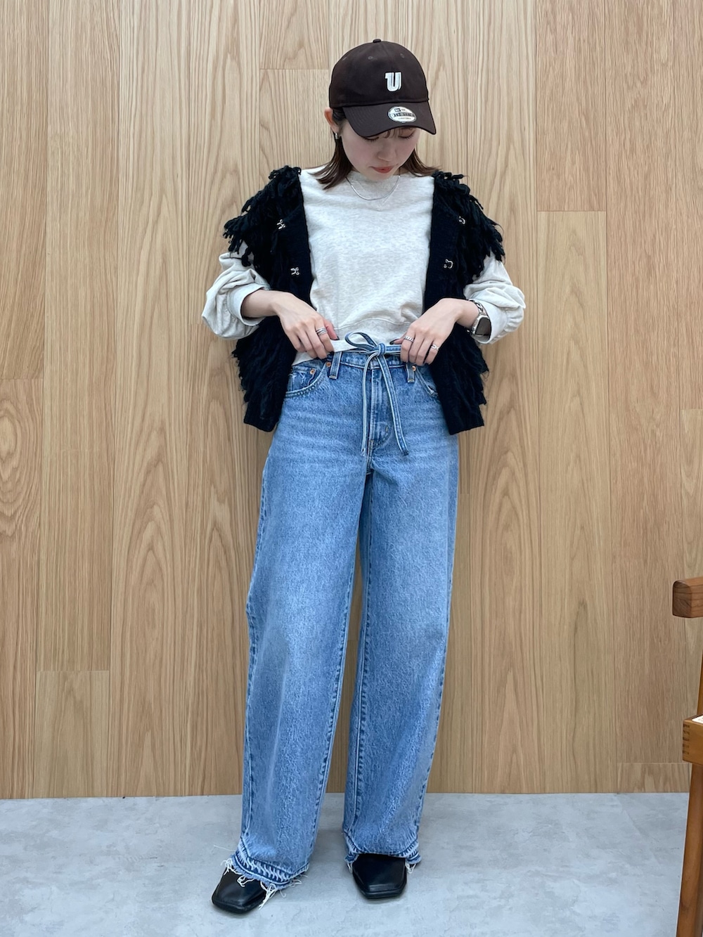 ブルー系のデニムパンツ、ブラック系のブーツ、グレー系のスウェットを着用したレディースの秋コーディネートの2枚目の写真