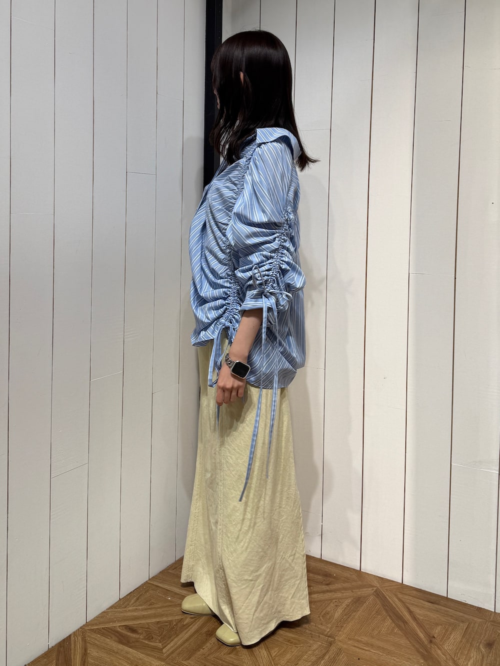 イエロー系のスカート、イエロー系のサンダル、ブルー系のシャツ/ブラウスを着用したレディースの春コーディネートの3枚目の写真