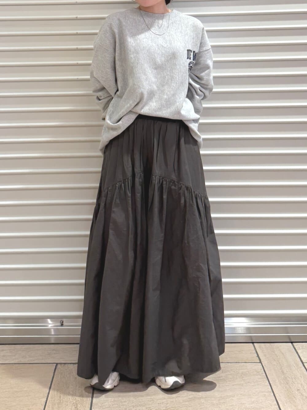 グレー系のスカート、グレー系のスウェットを着用したレディースの秋コーディネートの2枚目の写真