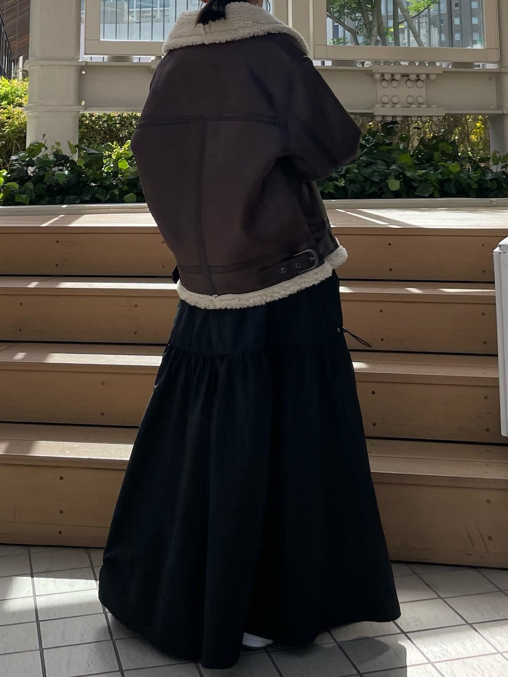 ブラック系のワンピース、ブラウン系のムートンコートを着用したレディースの秋コーディネートの5枚目の写真