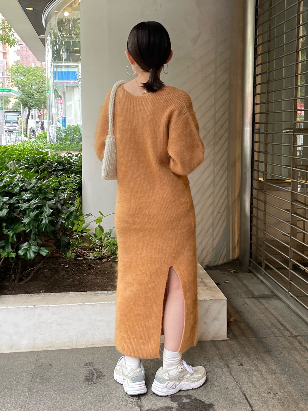 ホワイト系のハンドバッグ、オレンジ系のワンピースを着用したレディースの秋コーディネートの3枚目の写真