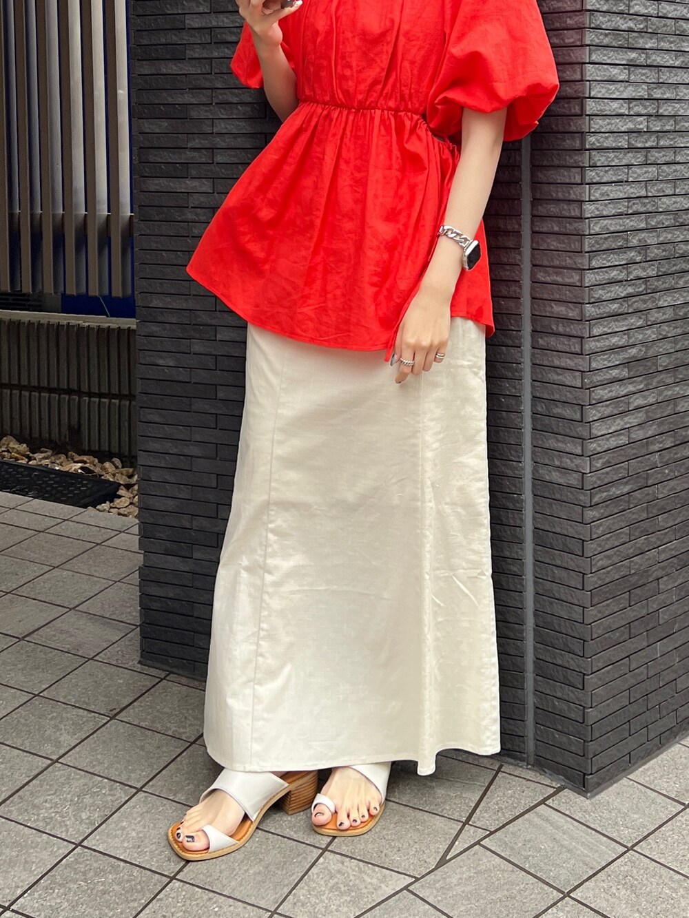 グレー系のキャミソール、ホワイト系のスカート、ホワイト系のサンダルを着用したレディースの春コーディネートの7枚目の写真