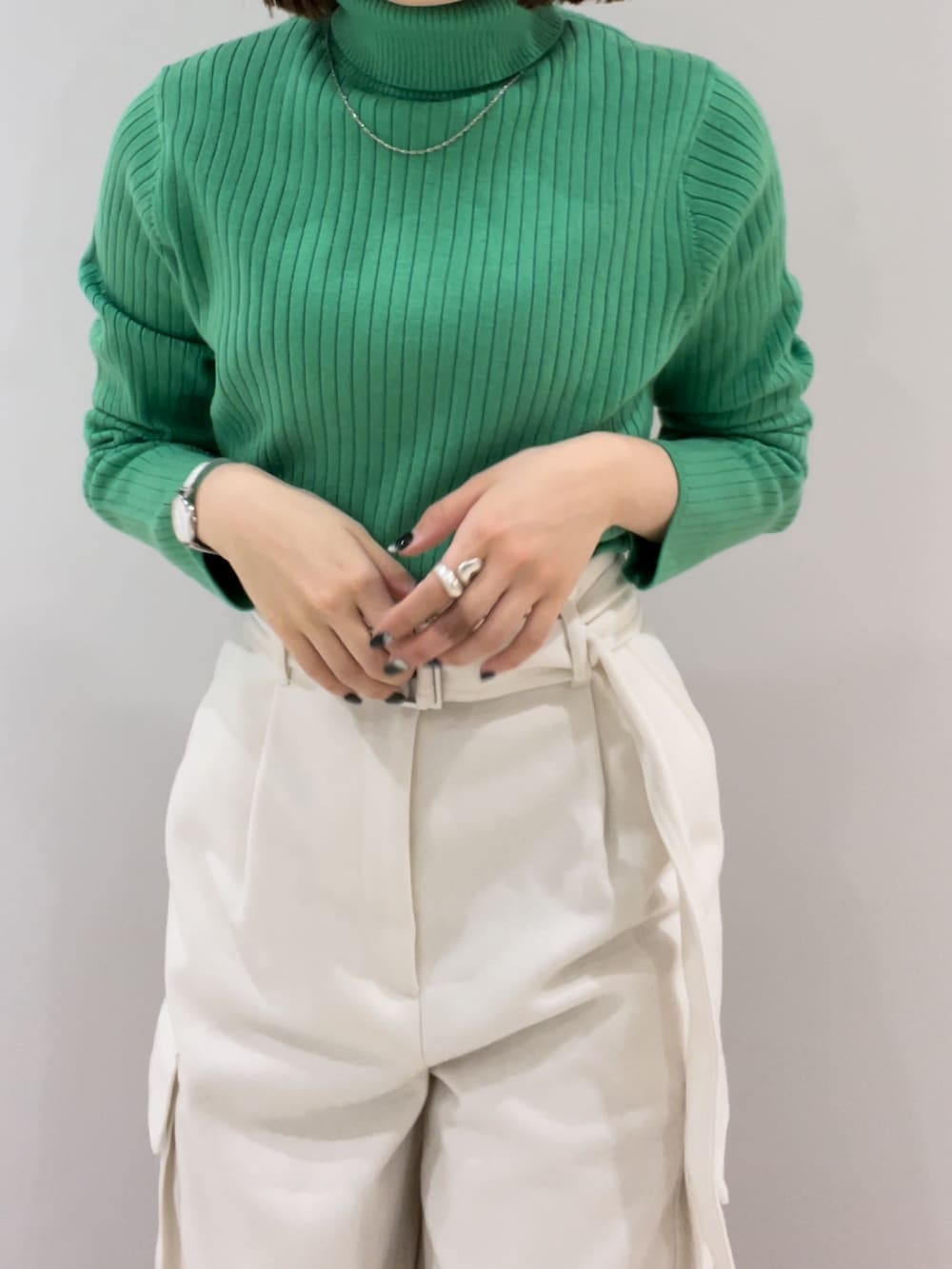 ブラック系のブーツ、ホワイト系のカーゴパンツ、グリーン系のニット/セーターを着用したレディースの冬コーディネートの4枚目の写真