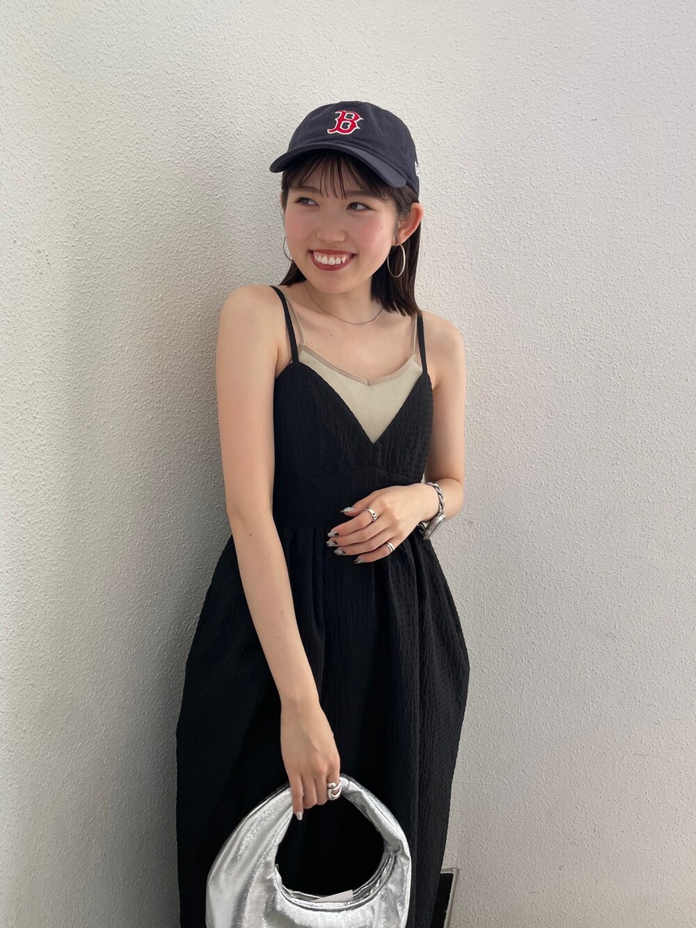 グレー系のキャミソール、シルバー系のハンドバッグ、ブラック系のワンピースを着用したレディースの春コーディネートの9枚目の写真