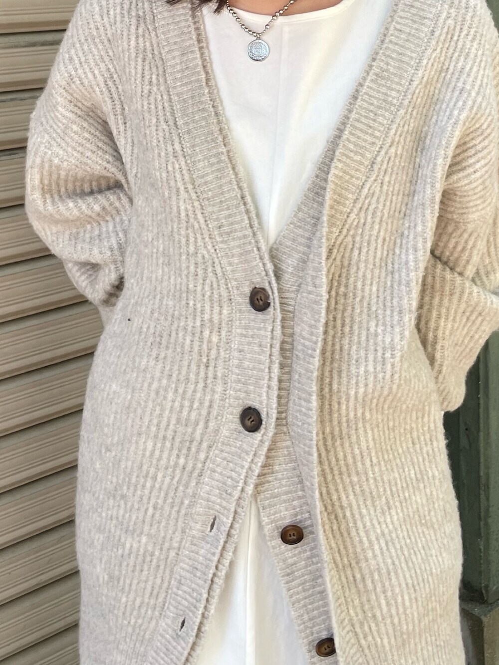 ホワイト系のカーディガン/ボレロ、ブラック系のワンピース、ブラック系のキャップを着用したレディースの秋コーディネートの7枚目の写真