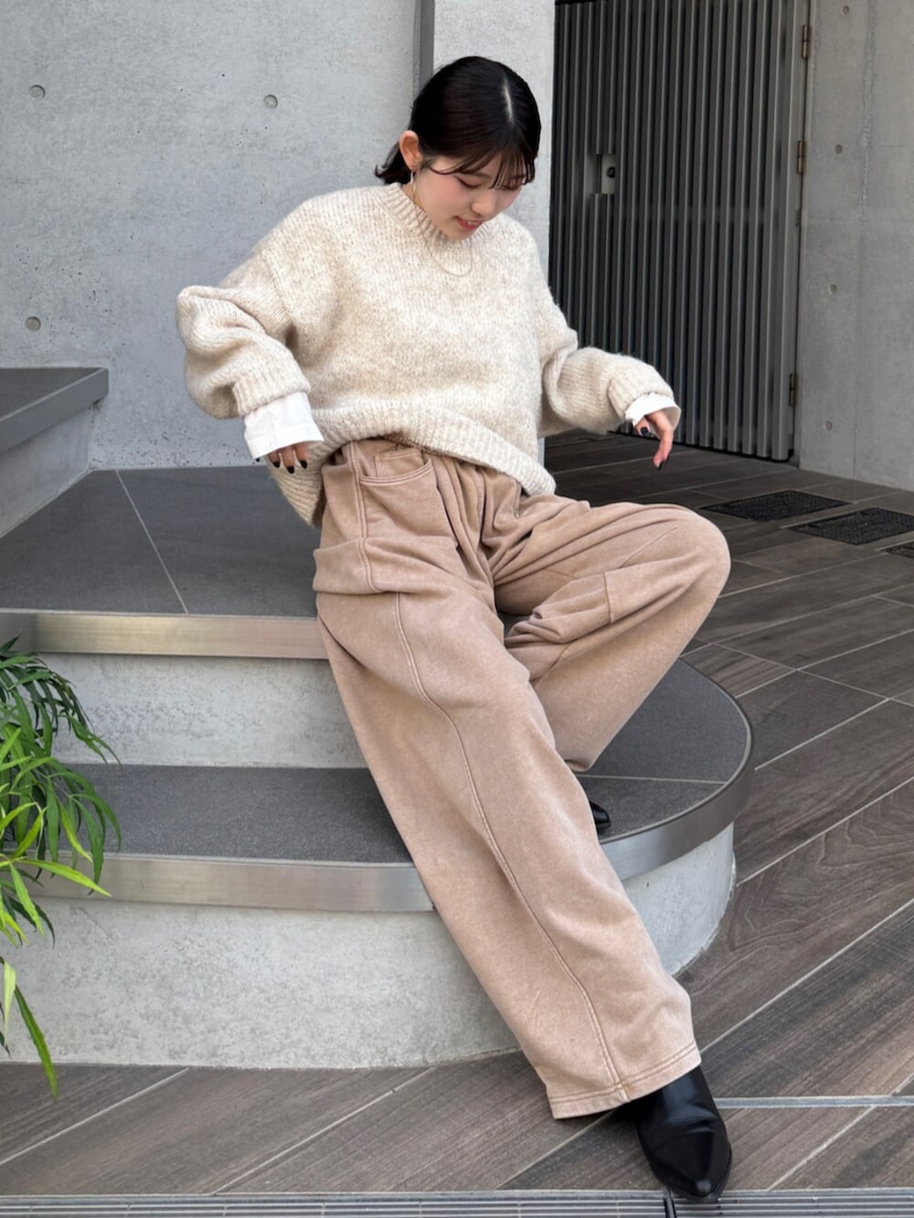 ベージュ系のスウェットパンツ、ブラック系のブーツ、ホワイト系のTシャツ/カットソーを着用したレディースの秋コーディネートの8枚目の写真