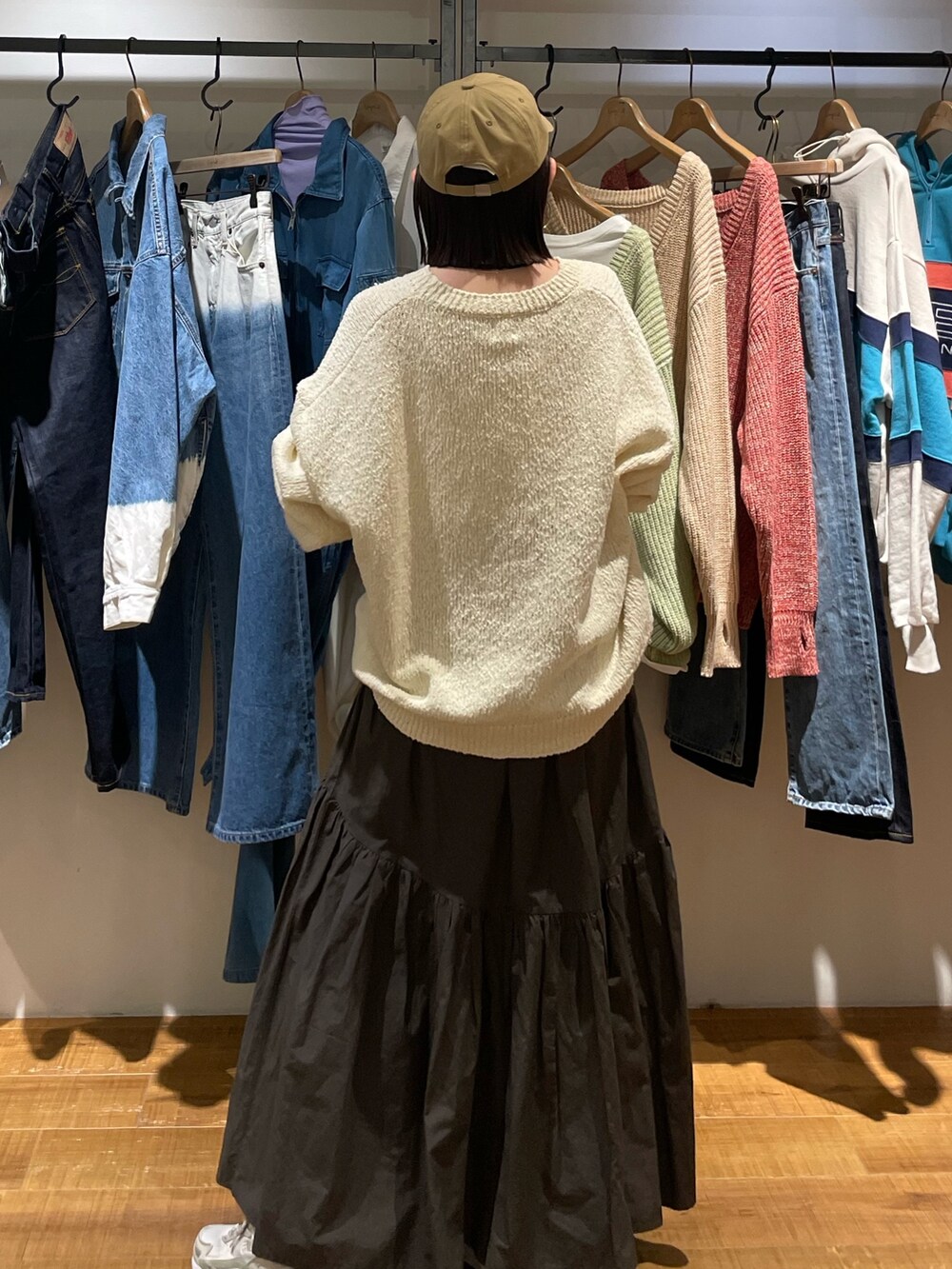 グレー系のスカート、ホワイト系のニット/セーター、ベージュ系のキャップを着用したレディースの冬コーディネートの3枚目の写真