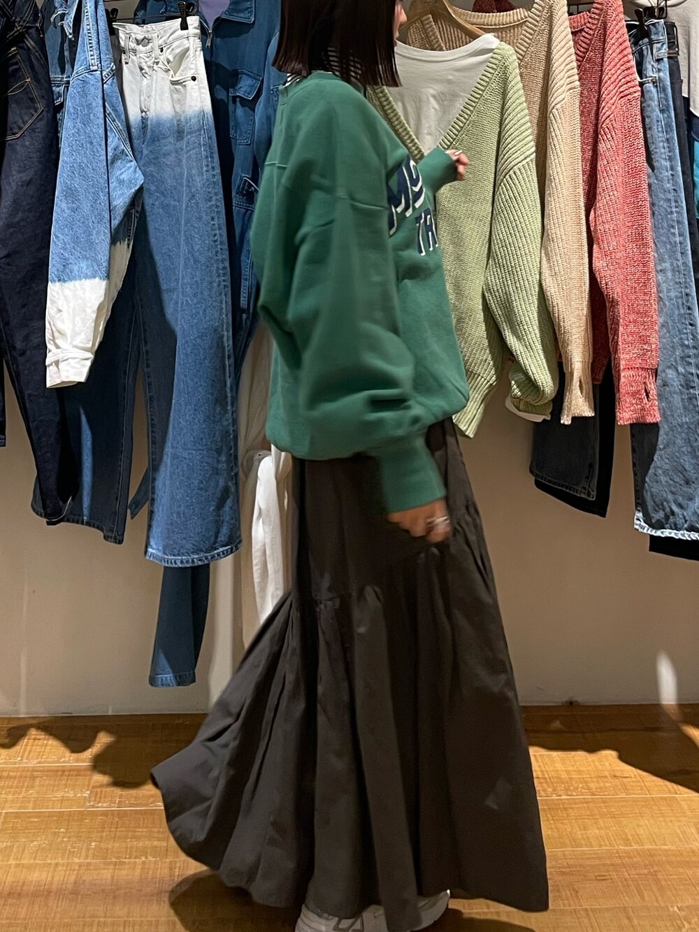 グレー系のスカート、グリーン系のスウェット、ホワイト系のニット/セーターを着用したレディースの冬コーディネートの5枚目の写真