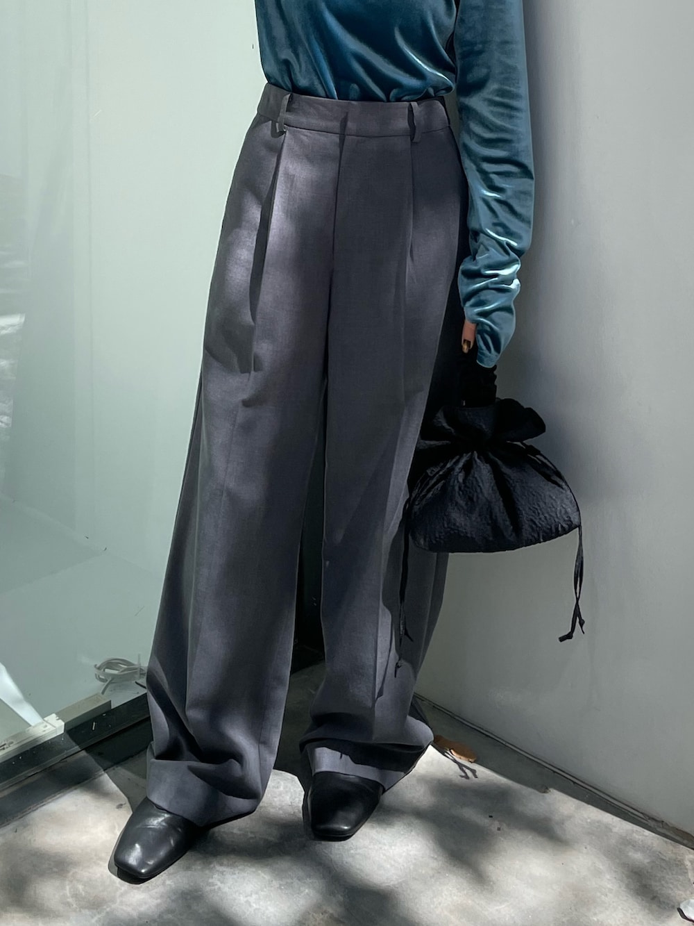 ブラック系のブーツ、ブラック系のハンドバッグ、ブルー系のTシャツ/カットソーを着用したレディースの秋コーディネートの5枚目の写真