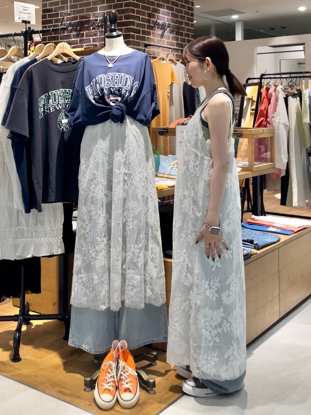 グリーン系のタンクトップ、ブルー系のデニムパンツ、ホワイト系のワンピースを着用したレディースの夏コーディネートの4枚目の写真