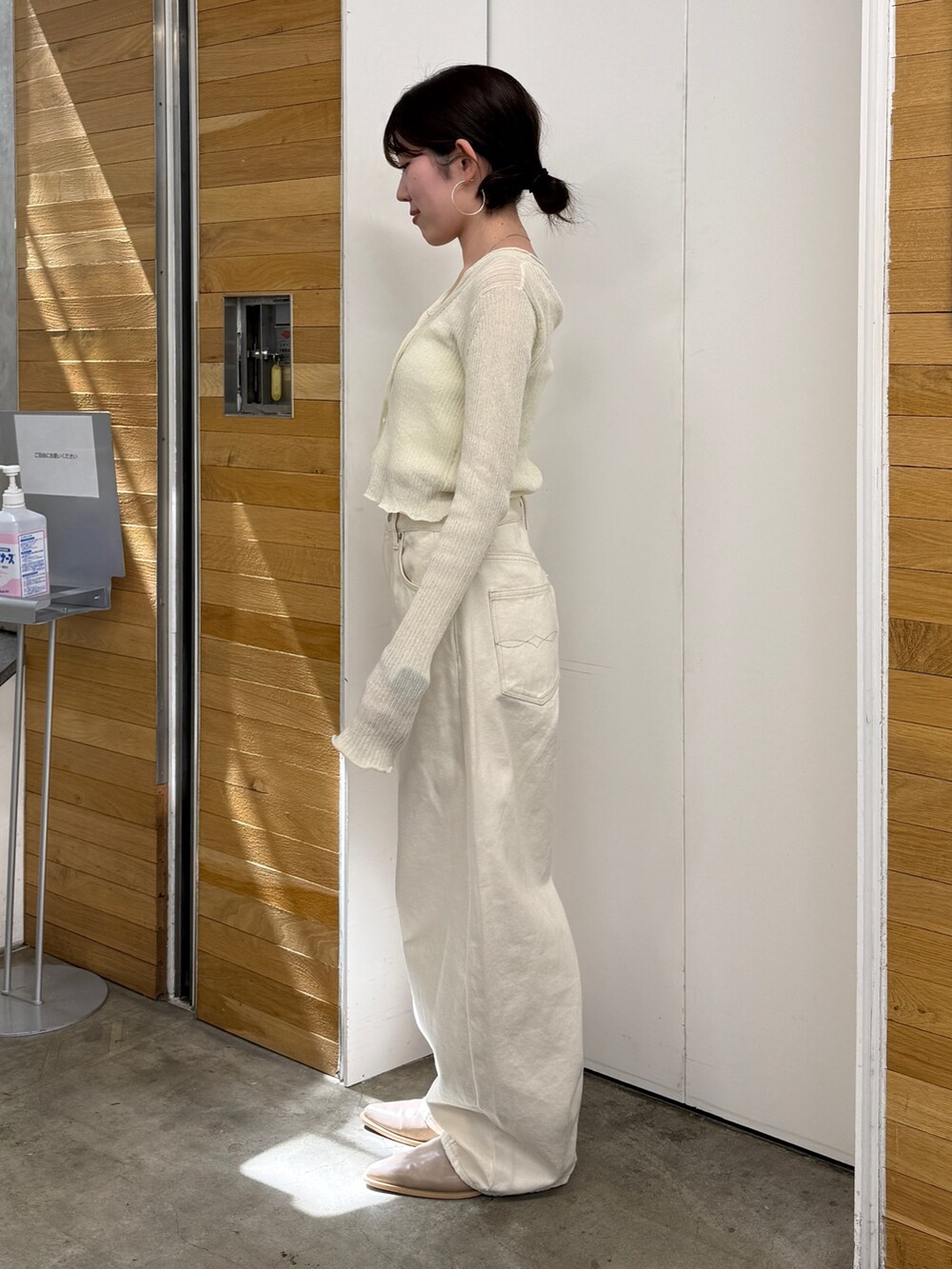 ホワイト系のデニムパンツ、ベージュ系のブーツ、ホワイト系のカーディガン/ボレロを着用したレディースの春コーディネートの4枚目の写真