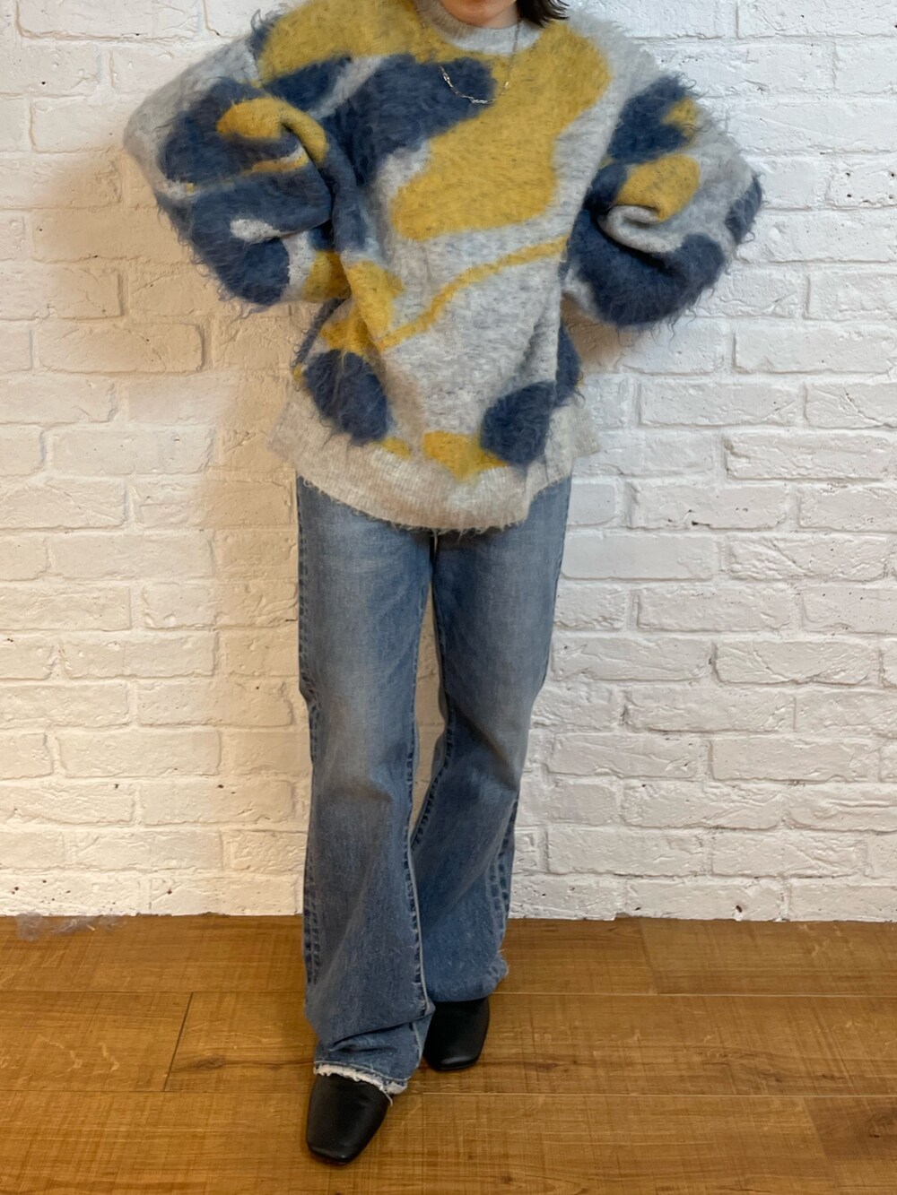 ブルー系のデニムパンツ、ブラック系のブーツ、ブルー系のニット/セーターを着用したレディースの夏コーディネートの4枚目の写真