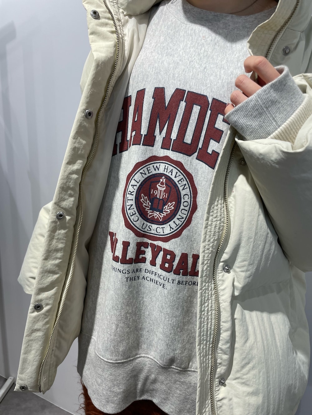 ブラック系のブーツ、ホワイト系のダウンジャケット/コート、オレンジ系のスカートを着用したレディースの秋コーディネートの8枚目の写真