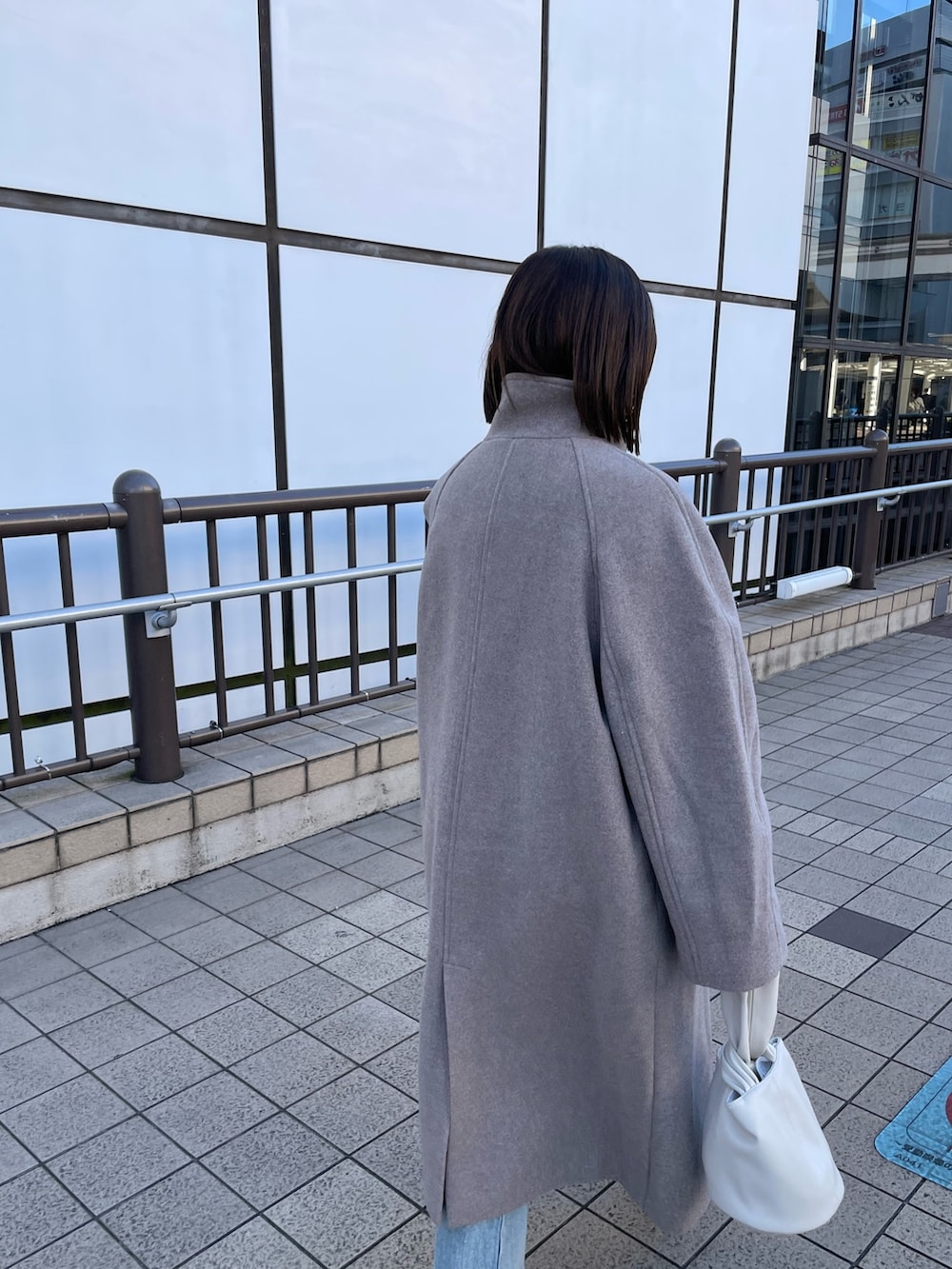 ホワイト系のブーツ、ホワイト系のハンドバッグ、グレー系のその他アウターを着用したレディースの冬コーディネートの4枚目の写真