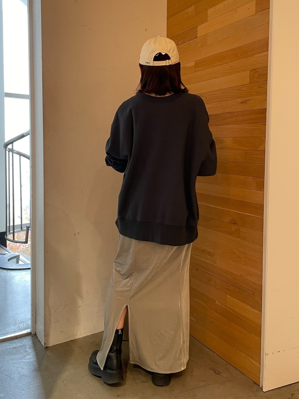 グレー系のスカート、ブラック系のブーツ、ブルー系のTシャツ/カットソーを着用したレディースの秋コーディネートの4枚目の写真