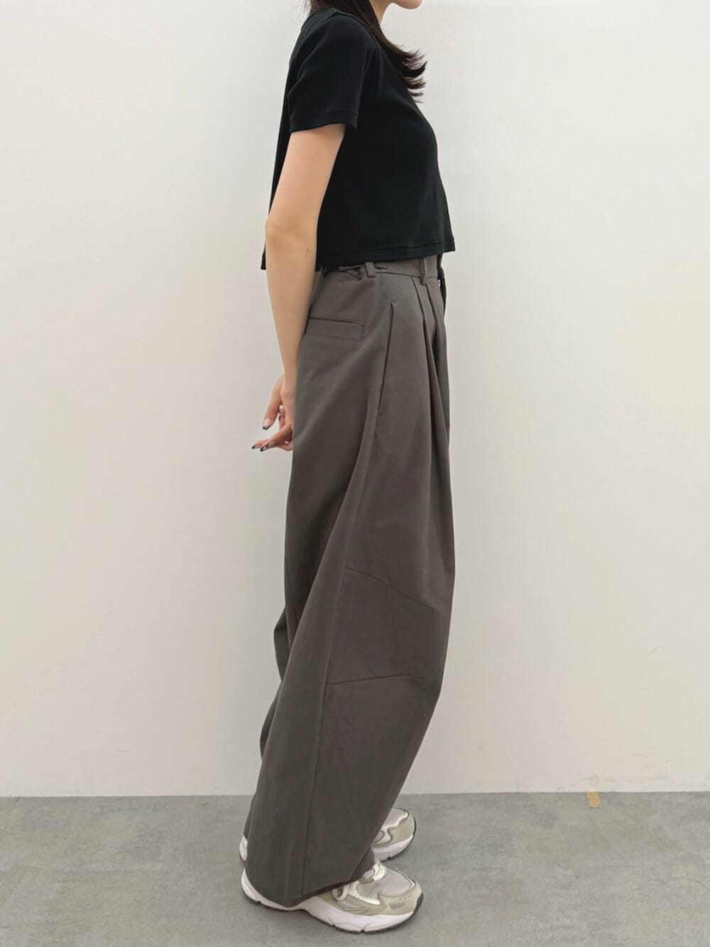 ブラック系のTシャツ/カットソー、グレー系のチノパンツ、ホワイト系のキャップを着用したレディースの春コーディネートの3枚目の写真