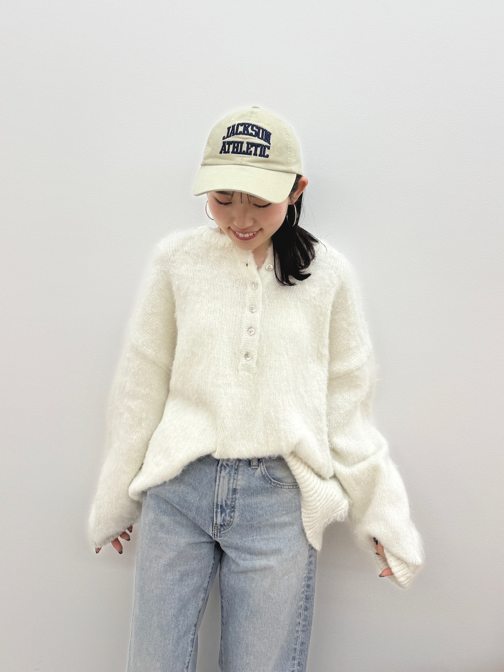 ホワイト系のニット/セーター、ブルー系のデニムパンツ、ブラウン系のブーツを着用したレディースの冬コーディネートの6枚目の写真