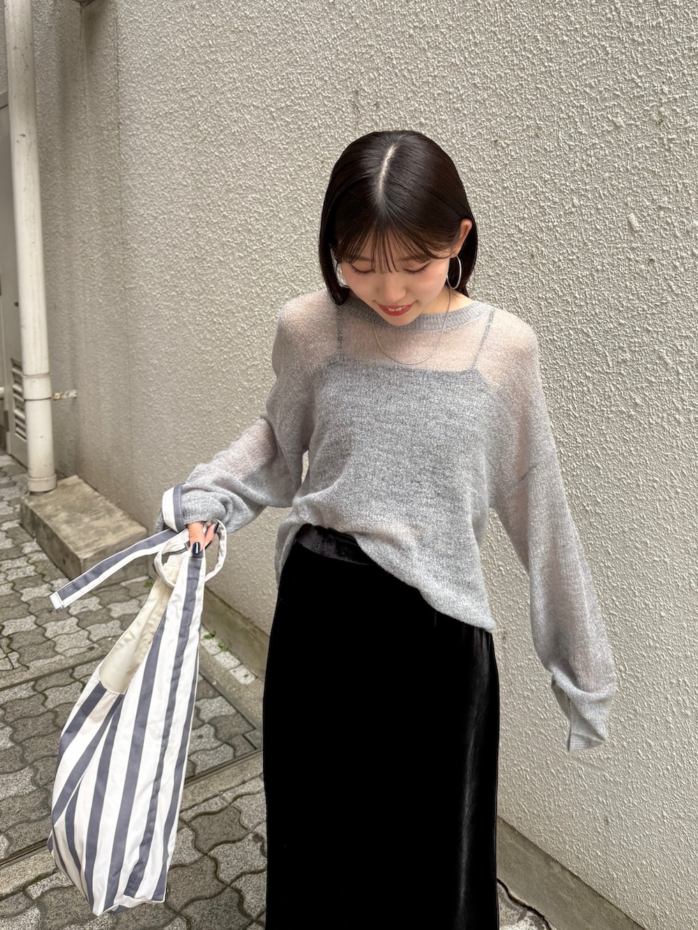 ブラック系のスカート、ブラウン系のブーツ、グレー系のニット/セーターを着用したレディースの秋コーディネートの6枚目の写真