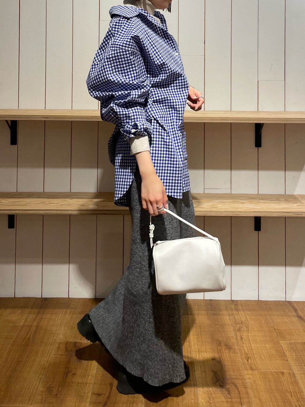 ホワイト系のハンドバッグ、ブルー系のシャツ/ブラウス、グレー系のスカートを着用したレディースの冬コーディネートの3枚目の写真
