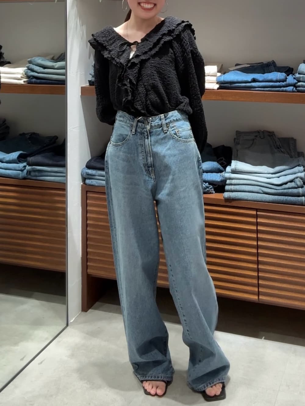 ブラック系のシャツ/ブラウス、ブルー系のデニムパンツを着用したレディースの春コーディネートの2枚目の写真