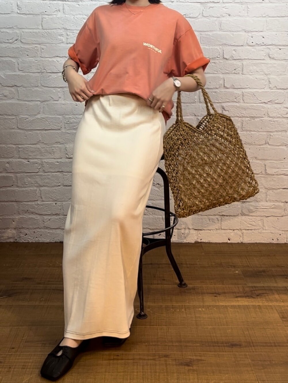 ホワイト系のスカート、イエロー系のハンドバッグ、ブラック系のパンプスを着用したレディースの春コーディネートの2枚目の写真