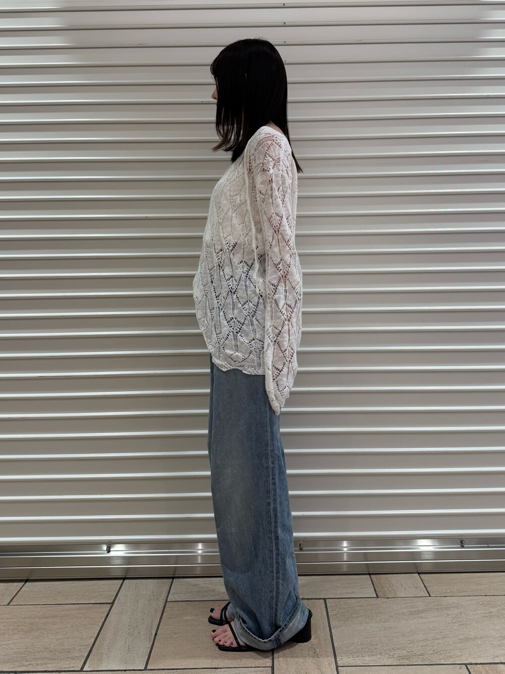 ブルー系のデニムパンツ、ホワイト系のニット/セーターを着用したレディースの夏コーディネートの4枚目の写真