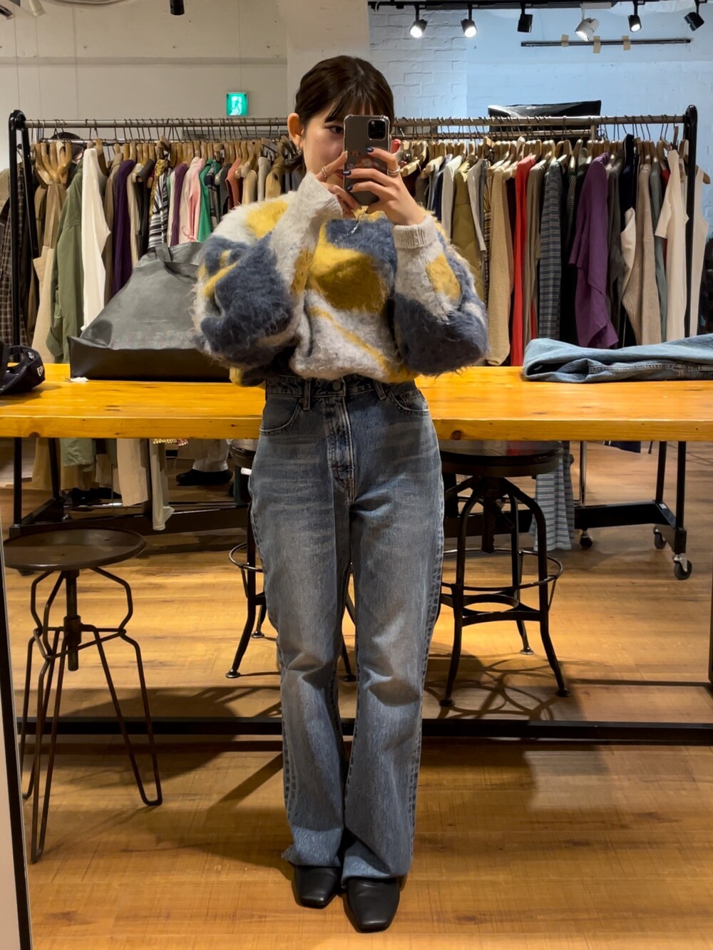 ブルー系のデニムパンツ、ブラック系のブーツ、ブルー系のニット/セーターを着用したレディースの夏コーディネートの2枚目の写真