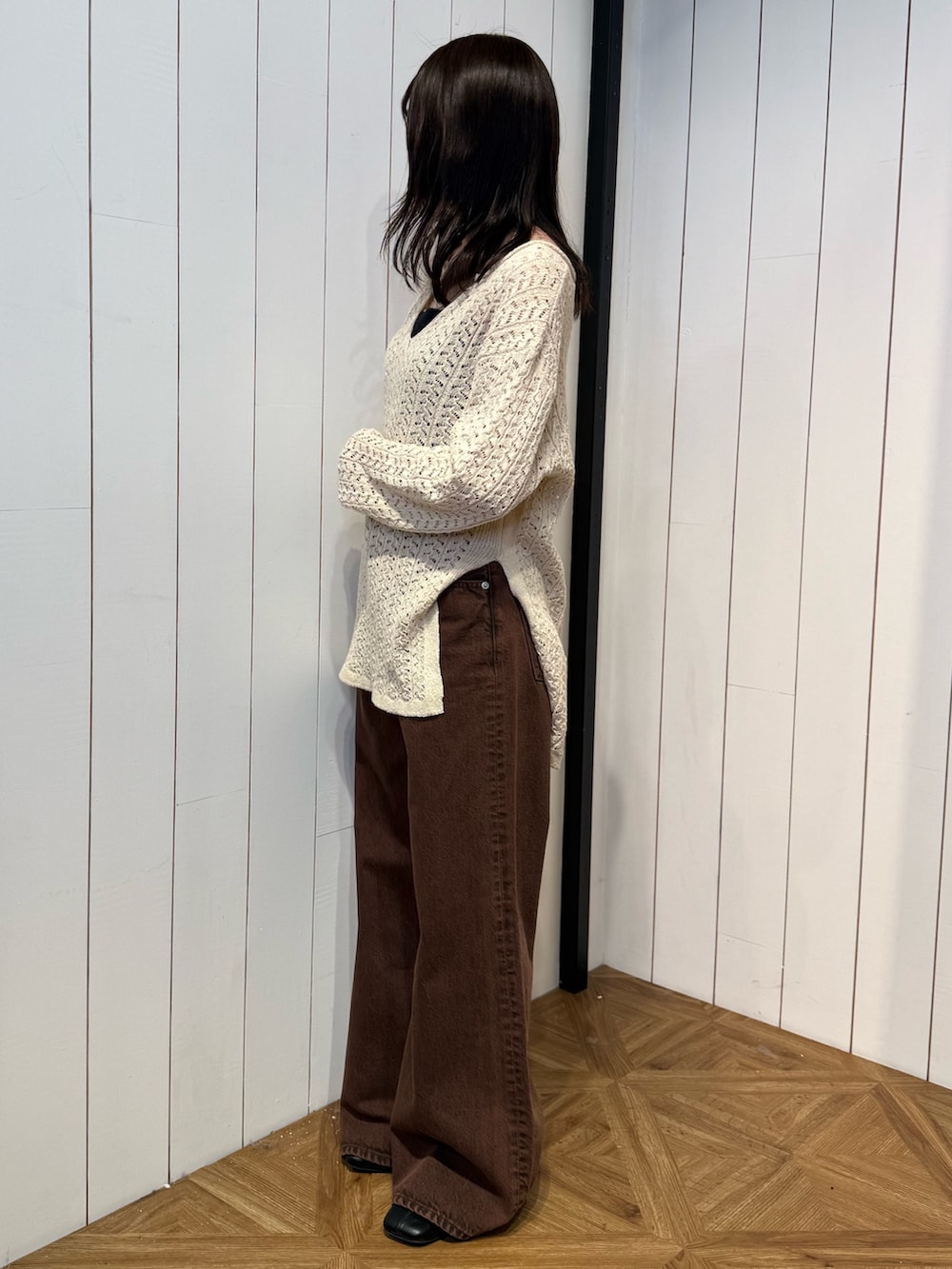 ブラウン系のデニムパンツ、ブラック系のサンダル、ベージュ系のニット/セーターを着用したレディースの春コーディネートの3枚目の写真