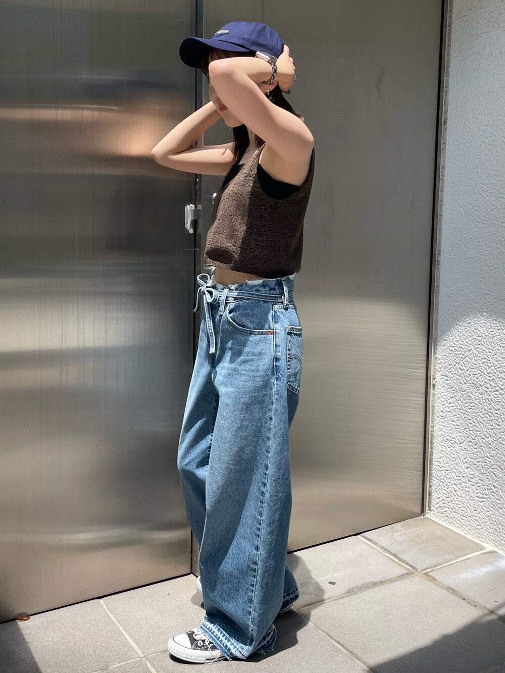 ブラウン系のベスト、ブルー系のデニムパンツ、ブルー系のキャップを着用したレディースの夏コーディネートの4枚目の写真