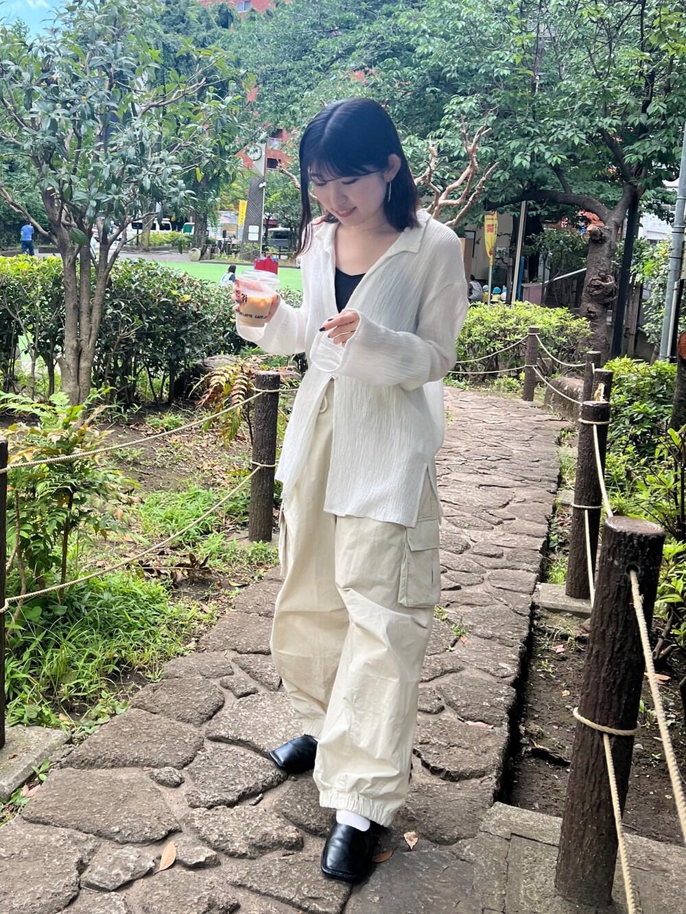 ブラック系のキャミソール、ホワイト系のシャツ/ブラウス、ホワイト系のカーゴパンツを着用したレディースの夏コーディネートの4枚目の写真