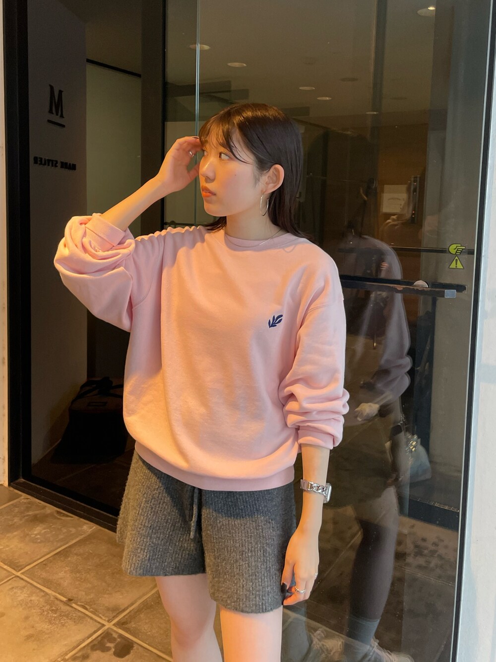 ピンク系のスウェット、グレー系のその他パンツを着用したレディースの秋コーディネートの2枚目の写真