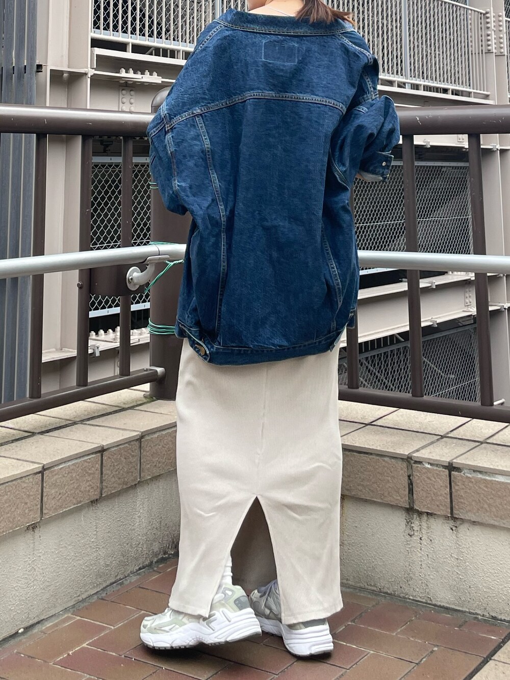 グレー系のワンピース、ブルー系のデニムジャケット、ブルー系のキャップを着用したレディースの夏コーディネートの9枚目の写真
