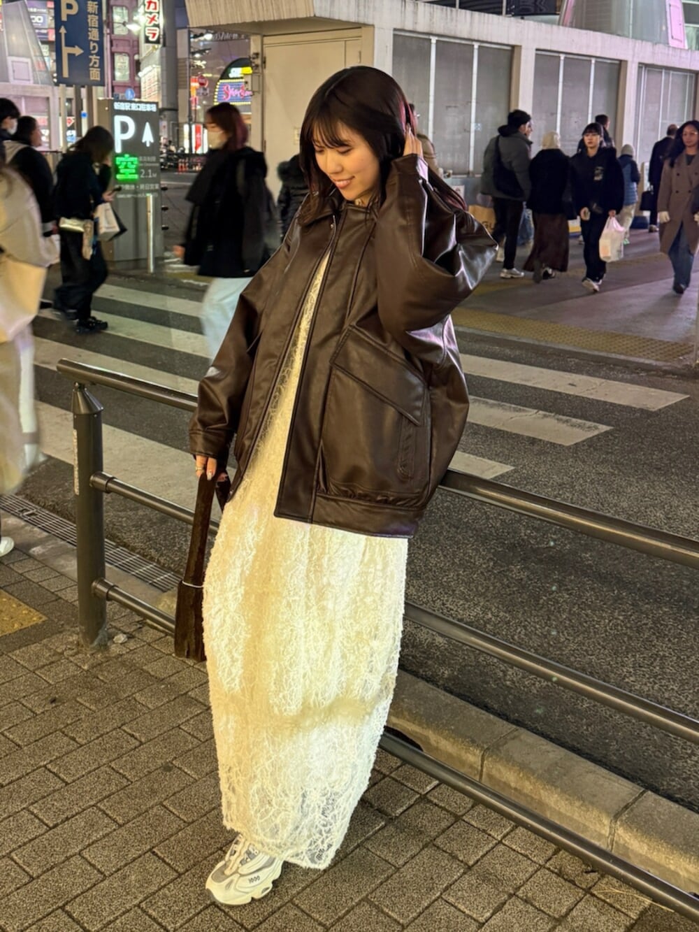 ブラウン系のハンドバッグ、ホワイト系のワンピース、ブラウン系のブルゾンを着用したレディースの冬コーディネートの7枚目の写真