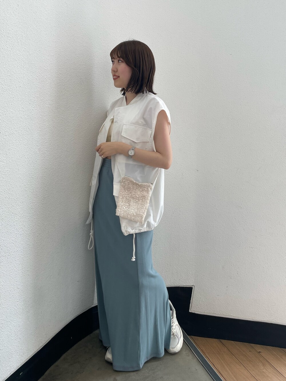 ホワイト系のショルダーバッグ、ホワイト系のキャミソール、ブルー系のスカートを着用したレディースの春コーディネートの3枚目の写真