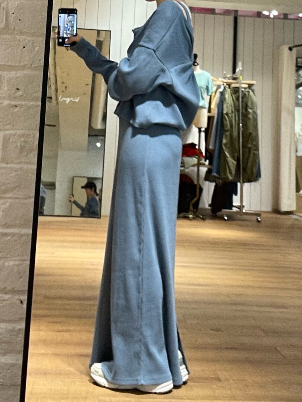 ブルー系のワンピース、グレー系のキャップを着用したレディースの春コーディネートの3枚目の写真