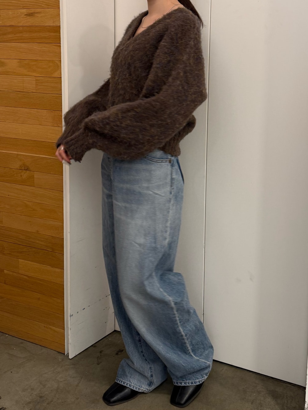 ブルー系のデニムパンツ、ブラック系のブーツ、ブラウン系のカーディガン/ボレロを着用したレディースの冬コーディネートの3枚目の写真