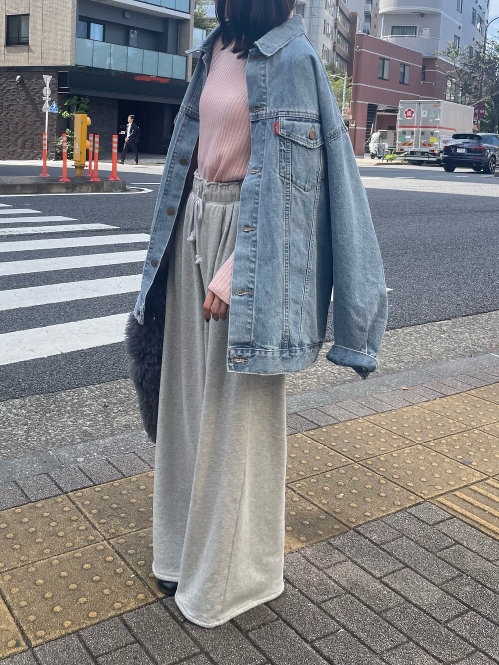 ピンク系のニット/セーター、グレー系のハンドバッグ、グレー系のスウェットパンツを着用したレディースの秋コーディネートの3枚目の写真