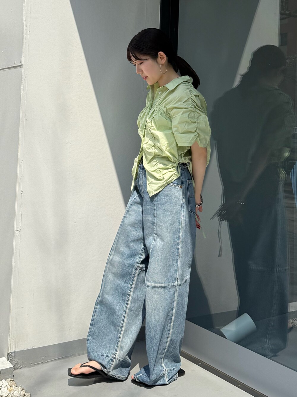 ブラック系のサンダル、ブルー系のデニムパンツ、グリーン系のシャツ/ブラウスを着用したレディースの春コーディネートの2枚目の写真