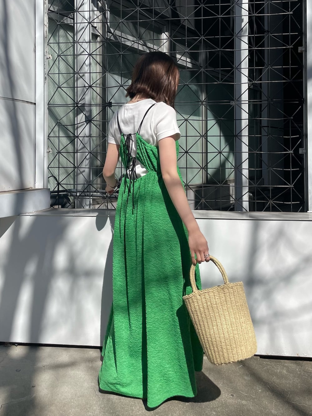 グリーン系のワンピース、ホワイト系のTシャツ/カットソー、ホワイト系のサンダルを着用したレディースの春コーディネートの3枚目の写真