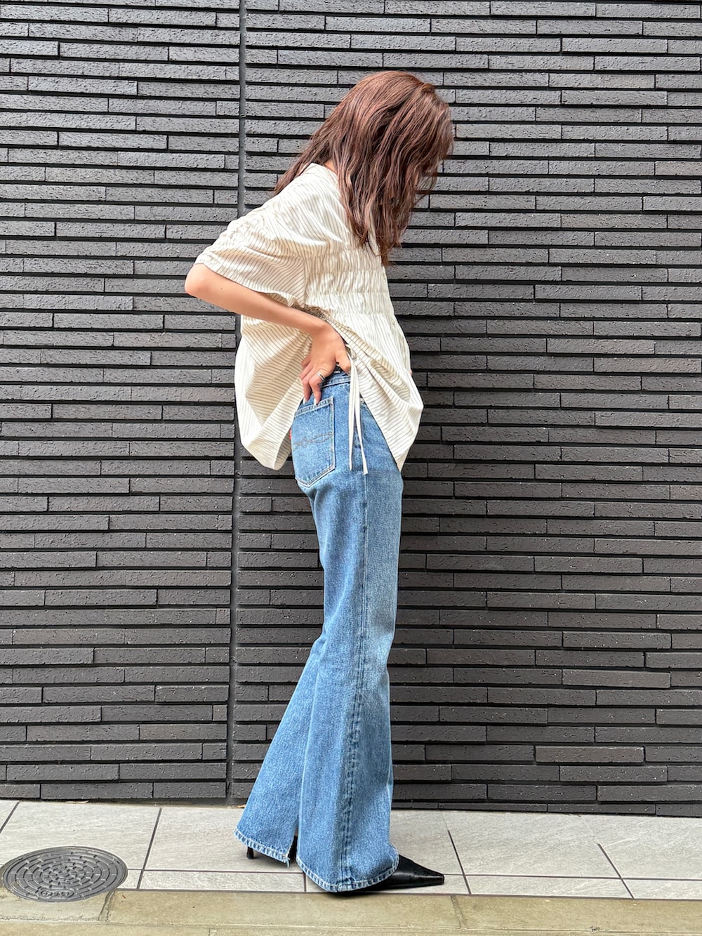 イエロー系のシャツ/ブラウス、ブルー系のデニムパンツを着用したレディースの夏コーディネートの2枚目の写真