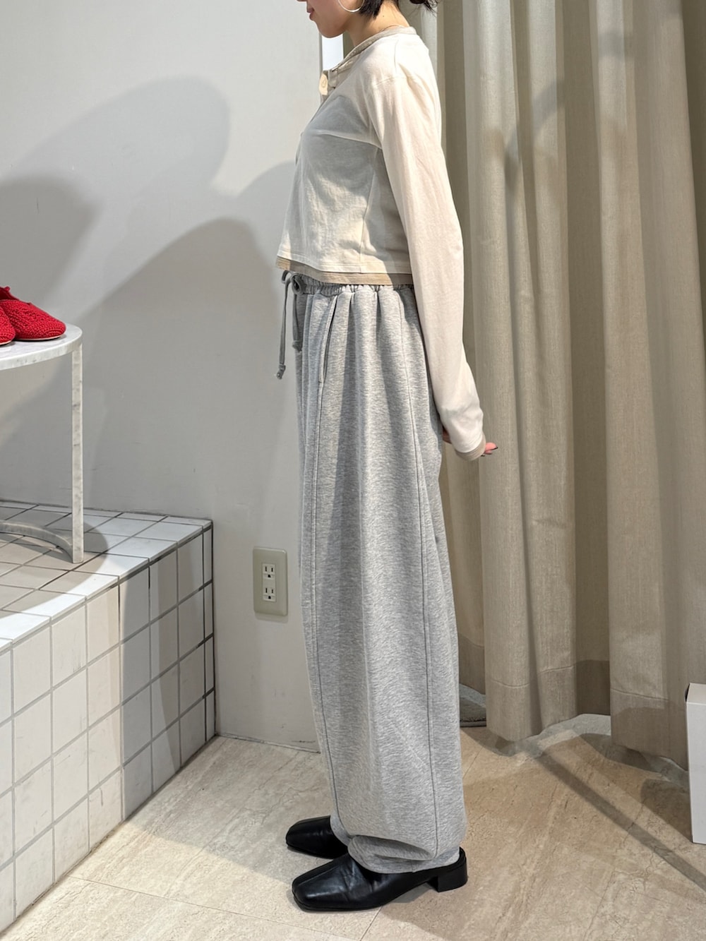 グレー系のスウェットパンツ、ブラック系のサンダル、ホワイト系のカーディガン/ボレロを着用したレディースの冬コーディネートの3枚目の写真