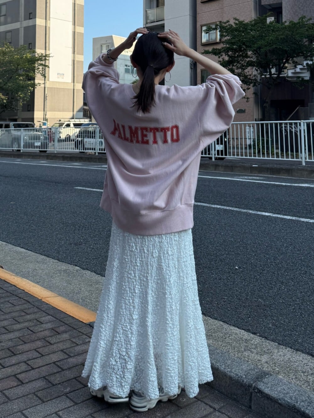 ホワイト系のスカート、ピンク系のスウェットを着用したレディースの秋コーディネートの4枚目の写真