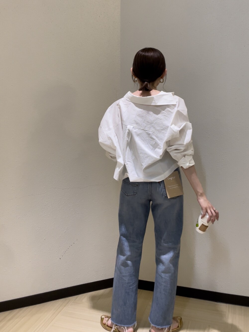 ブルー系のデニムパンツ、ベージュ系のキャミソール、ホワイト系のシャツ/ブラウスを着用したレディースの春コーディネートの4枚目の写真